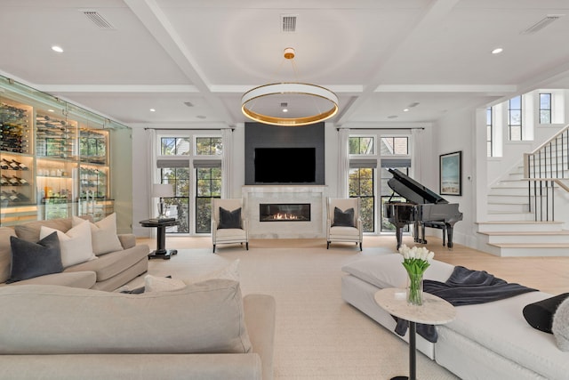 living room featuring coffered ceiling, plenty of natural light, and beamed ceiling