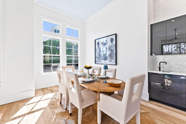 dining area with ornamental molding, ceiling fan, and light hardwood / wood-style flooring