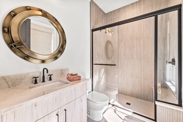 bathroom featuring vanity, toilet, and a shower with shower door