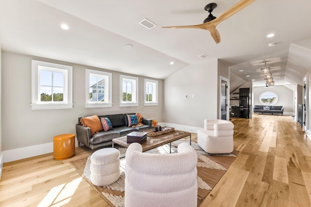 living room with ceiling fan, vaulted ceiling, and light hardwood / wood-style flooring