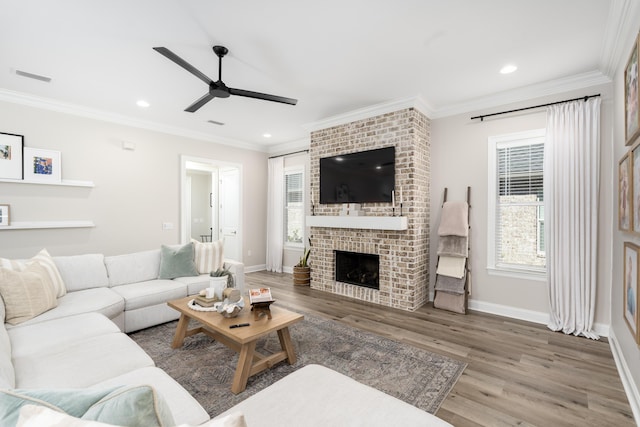 living room featuring wood finished floors, plenty of natural light, ceiling fan, and ornamental molding