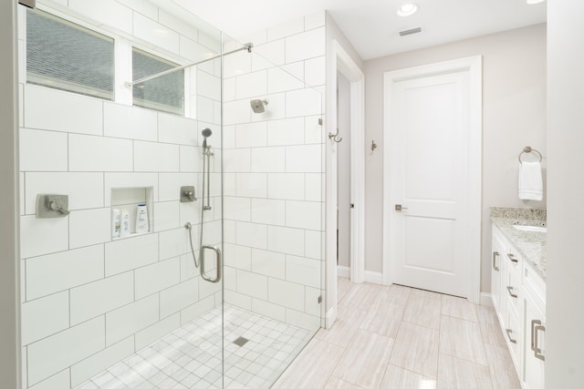 full bathroom with visible vents, baseboards, a stall shower, and vanity