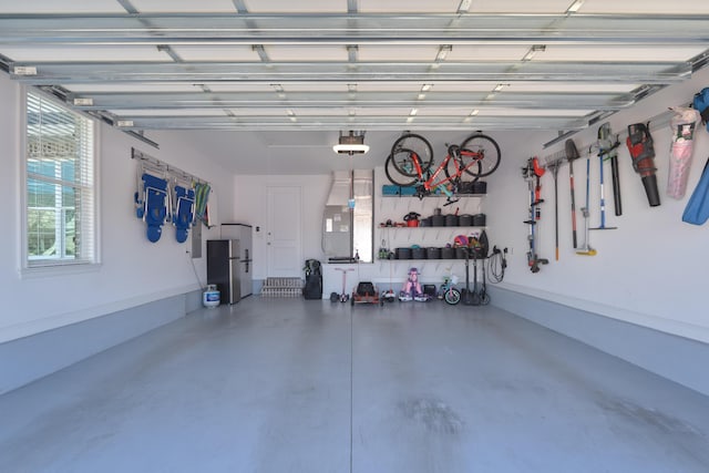 garage featuring a garage door opener and freestanding refrigerator