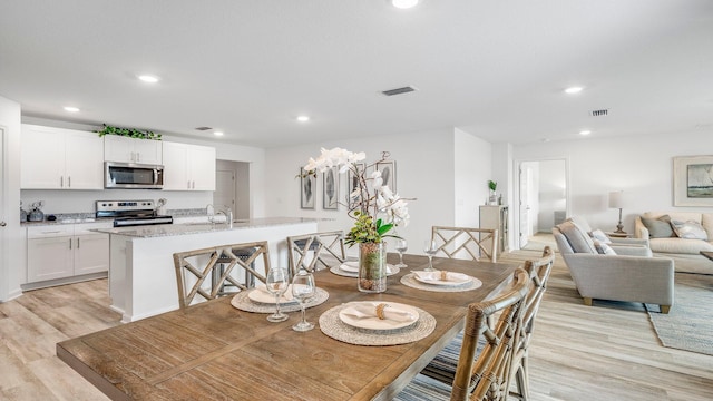 dining room with sink and light hardwood / wood-style flooring