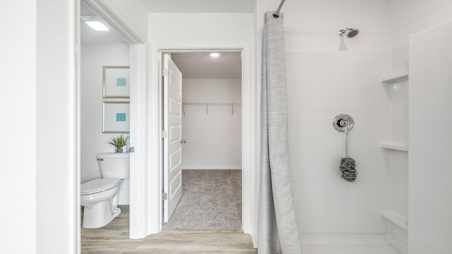 bathroom with a shower with curtain, wood-type flooring, and toilet