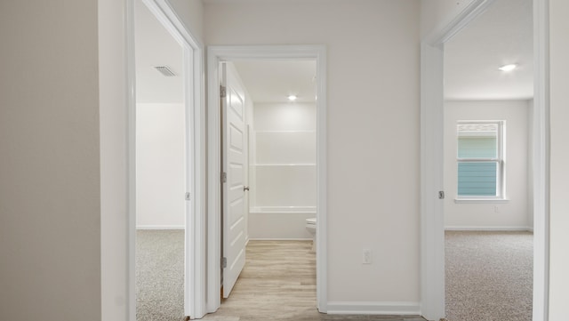 corridor featuring visible vents and baseboards
