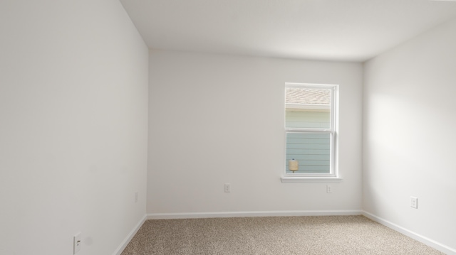 carpeted spare room with baseboards
