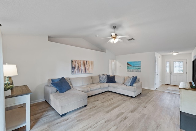 living room with ceiling fan, vaulted ceiling, and light wood-type flooring