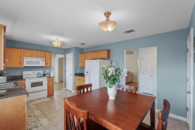 tiled dining space featuring a textured ceiling