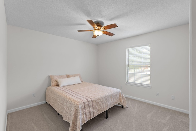 carpeted bedroom featuring ceiling fan and a textured ceiling