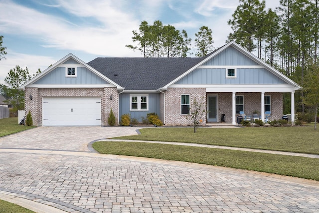 craftsman-style house featuring a garage, a front yard, and covered porch