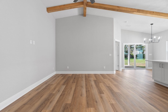 unfurnished living room featuring lofted ceiling with beams, a notable chandelier, and light wood-type flooring