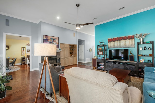 living room with dark hardwood / wood-style flooring, ornamental molding, and ceiling fan