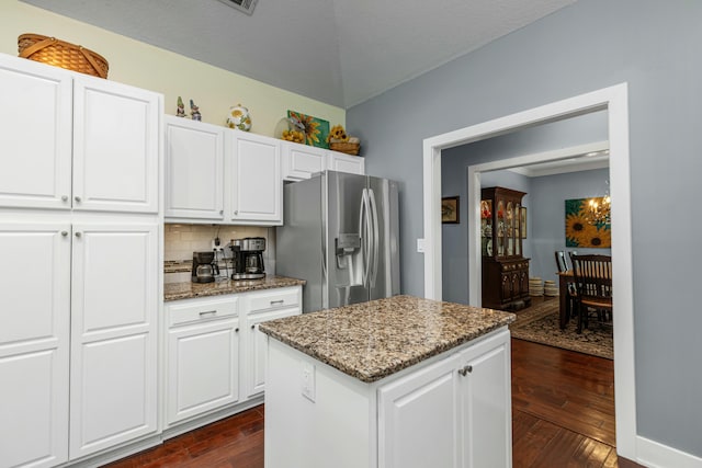 kitchen featuring stainless steel fridge, a kitchen island, dark hardwood / wood-style floors, white cabinets, and stone countertops