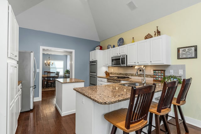 kitchen with stainless steel appliances, a breakfast bar, kitchen peninsula, and a kitchen island