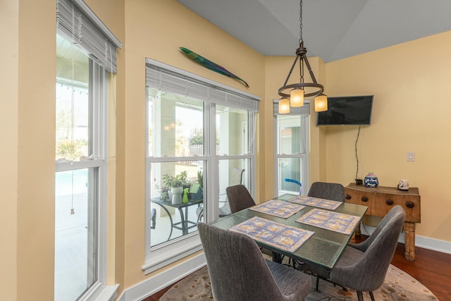 dining area with plenty of natural light, dark hardwood / wood-style floors, and lofted ceiling