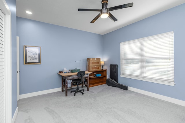 carpeted office space featuring ceiling fan