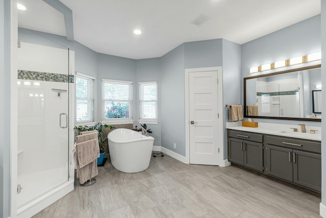 bathroom featuring plus walk in shower and vanity