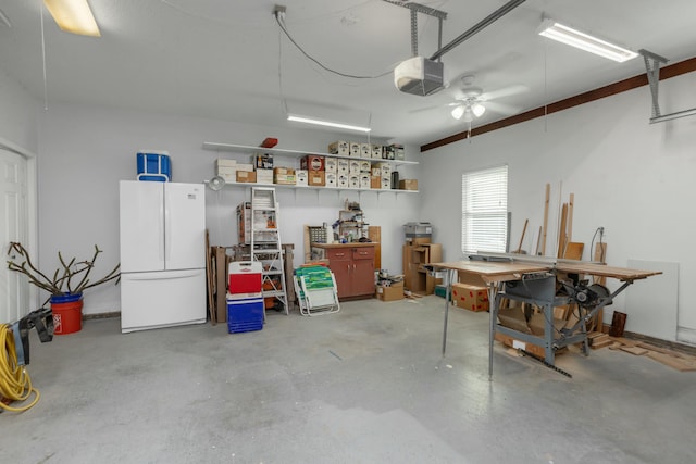 garage with white refrigerator, a garage door opener, and a workshop area