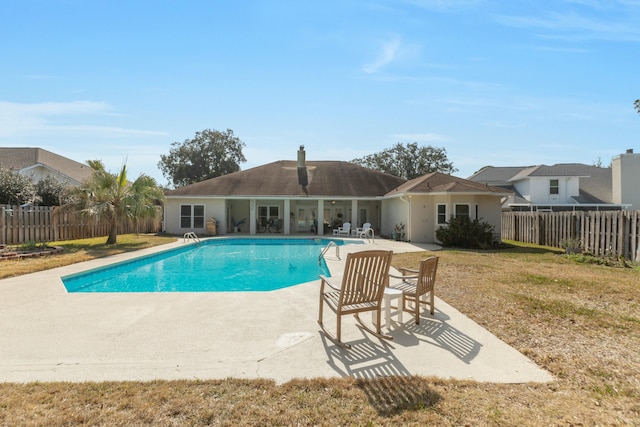 view of swimming pool featuring a lawn and a patio