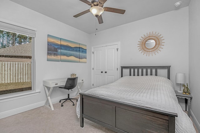 bedroom featuring light carpet, a closet, a ceiling fan, and baseboards