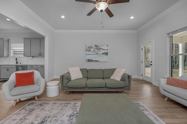 living area with light wood finished floors, baseboards, crown molding, and recessed lighting