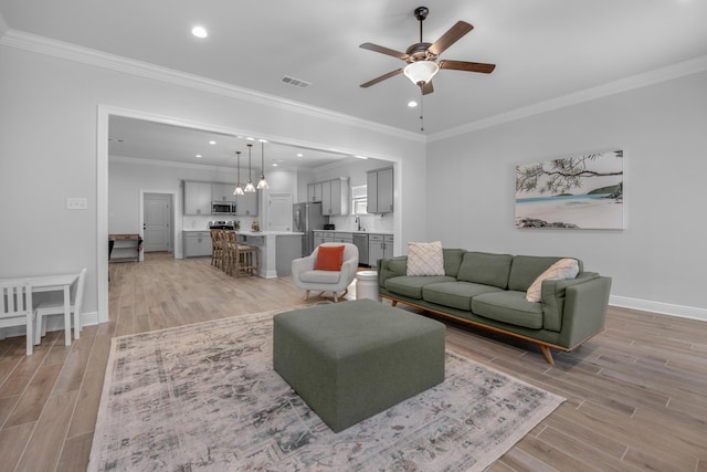 living area with recessed lighting, ceiling fan with notable chandelier, visible vents, baseboards, and light wood finished floors