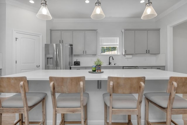 kitchen featuring gray cabinetry, light countertops, a large island, and stainless steel fridge with ice dispenser