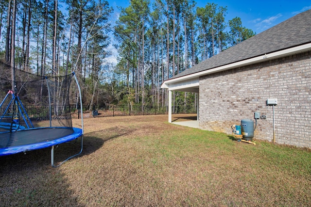 view of yard featuring a trampoline and fence private yard