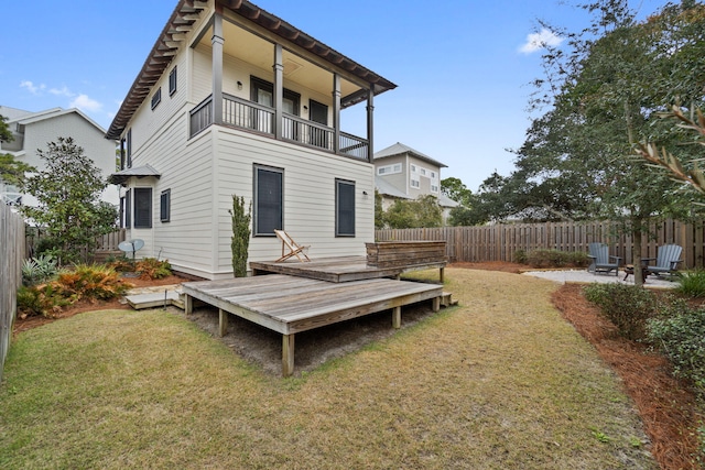 back of property with a patio, a balcony, a deck, and a lawn