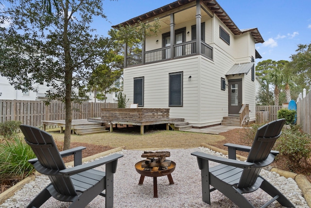 rear view of house featuring a balcony, a deck, and an outdoor fire pit