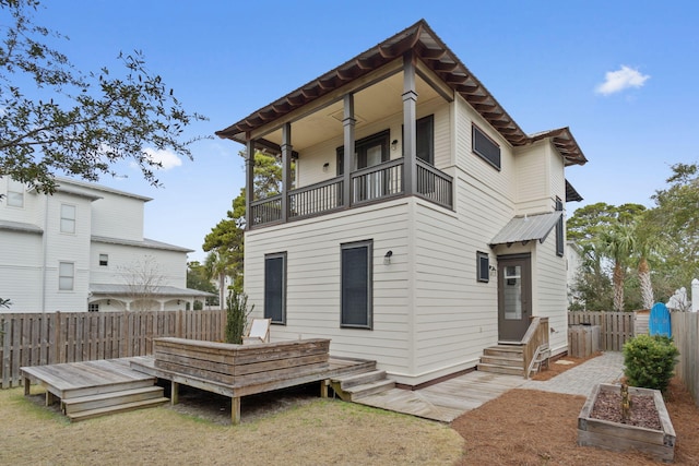 rear view of property featuring a wooden deck and a balcony