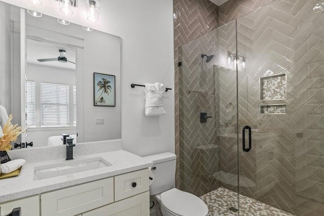 bathroom with ceiling fan, vanity, toilet, and a shower with shower door