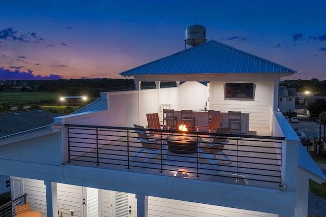 back house at dusk with a balcony