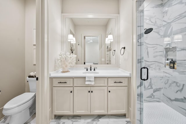 bathroom featuring vanity, a shower with door, and toilet