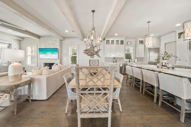 dining room featuring beam ceiling, dark wood-type flooring, and a chandelier