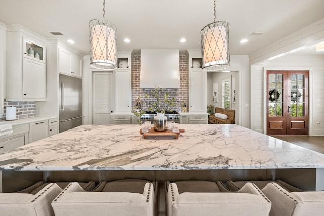 kitchen featuring pendant lighting, premium appliances, a kitchen breakfast bar, and a large island