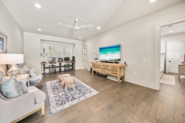 living room featuring dark wood-type flooring and ceiling fan