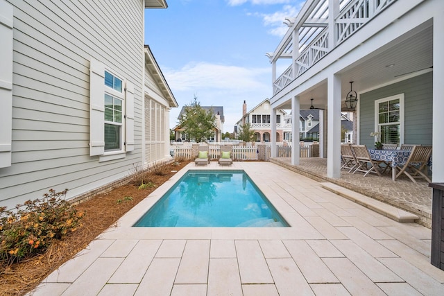 view of swimming pool with ceiling fan and a patio