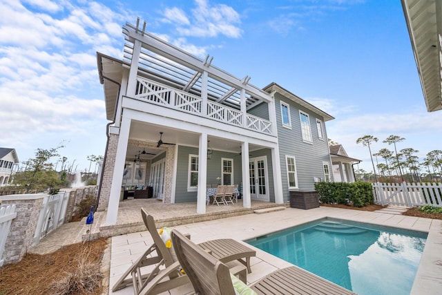 rear view of house with a fenced in pool, a patio, a balcony, and ceiling fan