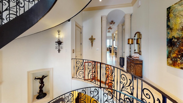 hallway featuring ornate columns and crown molding