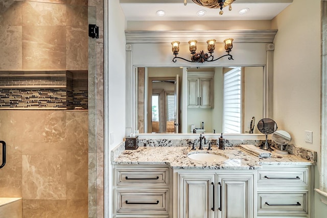 bathroom with a shower with door and vanity