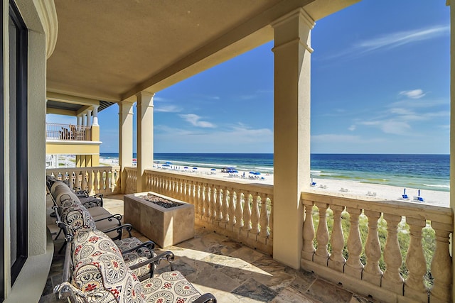 balcony featuring a view of the beach and a water view