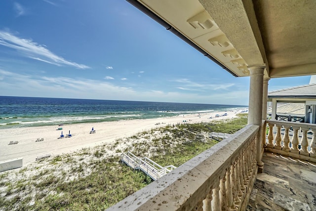 balcony with a water view and a beach view