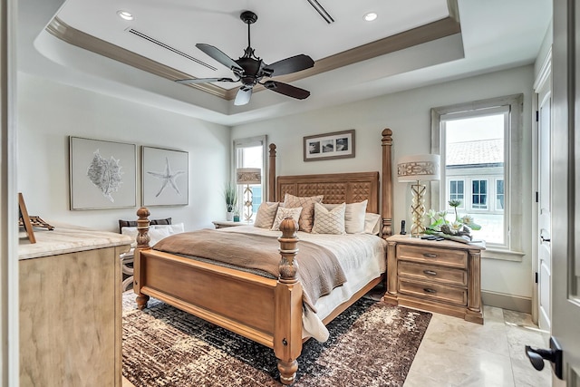 bedroom with a raised ceiling and ceiling fan