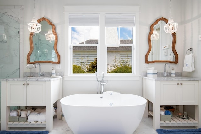 bathroom with a soaking tub, two vanities, marble finish floor, and a sink