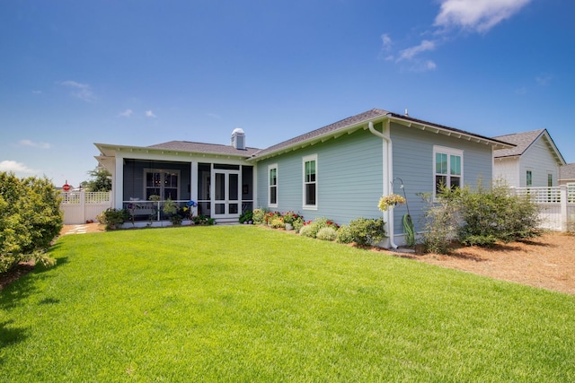 back of house with a yard, fence, a sunroom, and a chimney