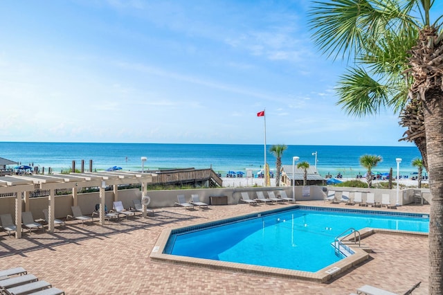 view of pool with a patio and a water view