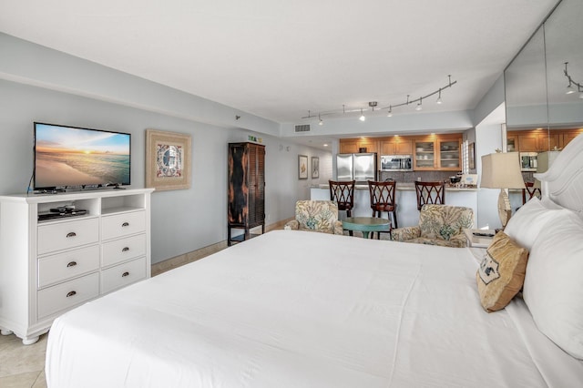 bedroom with stainless steel refrigerator