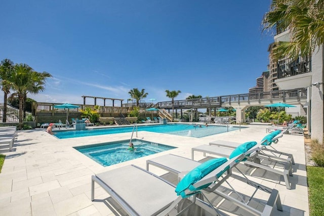 view of swimming pool featuring a community hot tub and a patio area